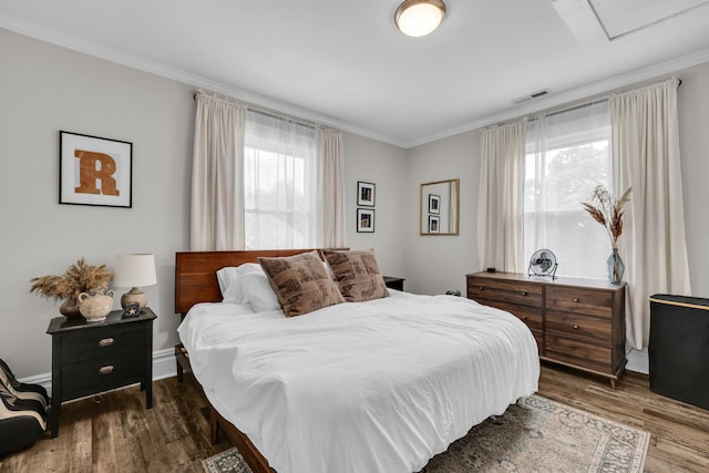 bedroom with crown molding, visible vents, multiple windows, and dark wood-type flooring