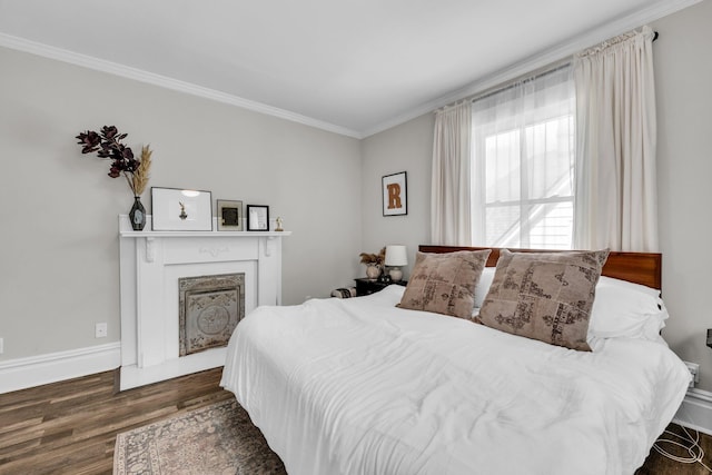 bedroom with crown molding, baseboards, wood finished floors, and a fireplace