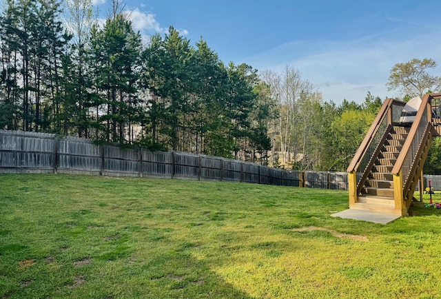 view of yard with stairs and a fenced backyard