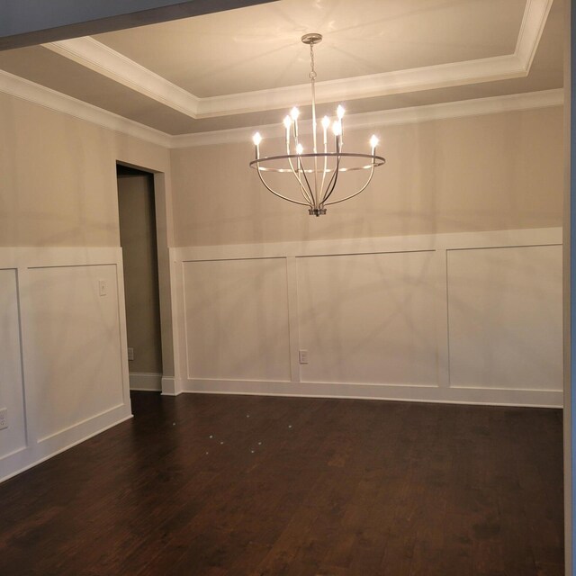 9573 Hastings Way, Ooltewah, TN 37363 - unfurnished dining area featuring crown molding, an inviting chandelier, a decorative wall, dark wood-type flooring, and a raised ceiling