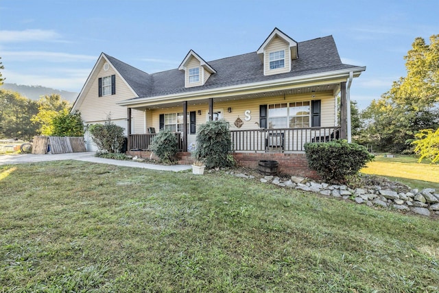 new england style home featuring roof with shingles, a front lawn, a garage, covered porch, and driveway