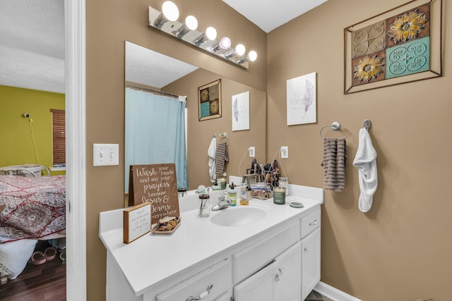 ensuite bathroom with vanity, ensuite bathroom, and wood finished floors