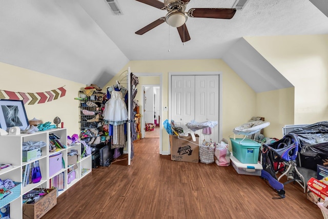 recreation room with ceiling fan, visible vents, wood finished floors, and lofted ceiling