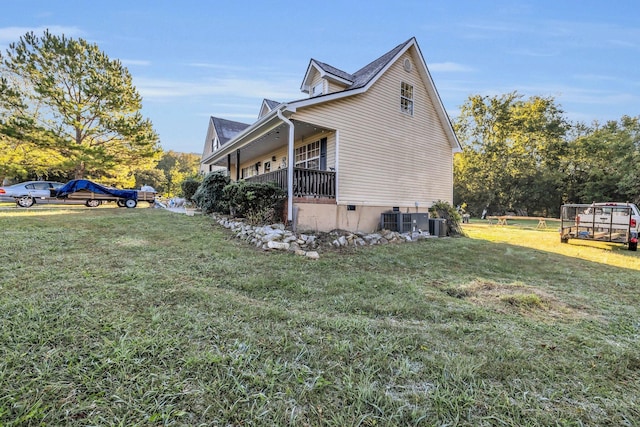 view of side of property with central air condition unit, a yard, and a porch
