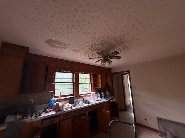 kitchen featuring a sink, a textured ceiling, open shelves, light countertops, and a ceiling fan