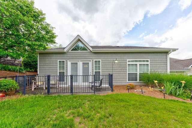 rear view of property featuring a lawn, fence, and a patio area