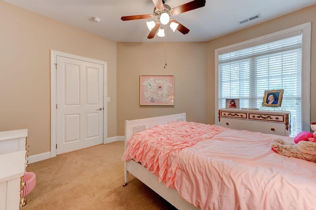 bedroom featuring visible vents, a ceiling fan, baseboards, and light carpet