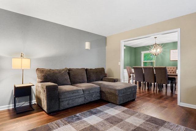 living room with an inviting chandelier, baseboards, and wood finished floors