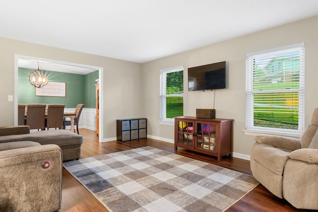 living area with plenty of natural light, a chandelier, and wood finished floors