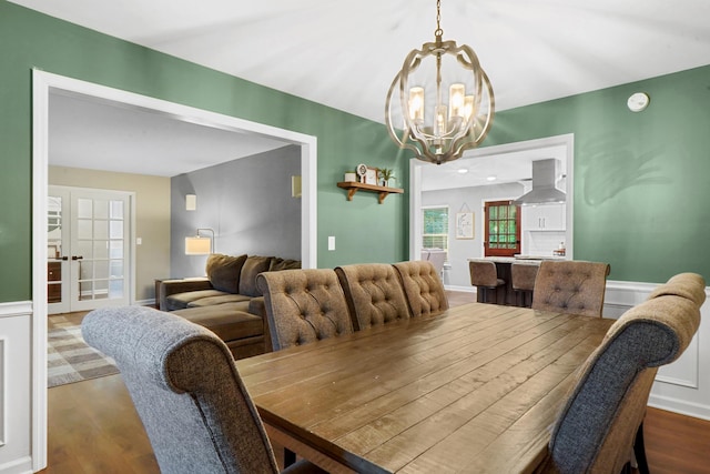 dining area with wainscoting, a notable chandelier, and dark wood finished floors