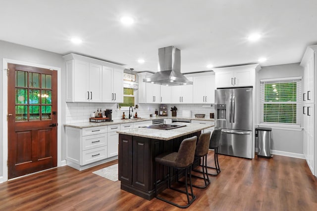 kitchen featuring white cabinets, island exhaust hood, stainless steel refrigerator with ice dispenser, and a sink