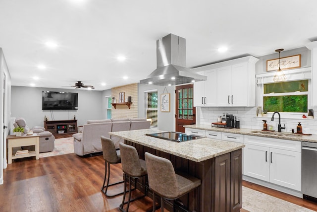 kitchen featuring island exhaust hood, a sink, stainless steel dishwasher, a kitchen island, and black electric stovetop