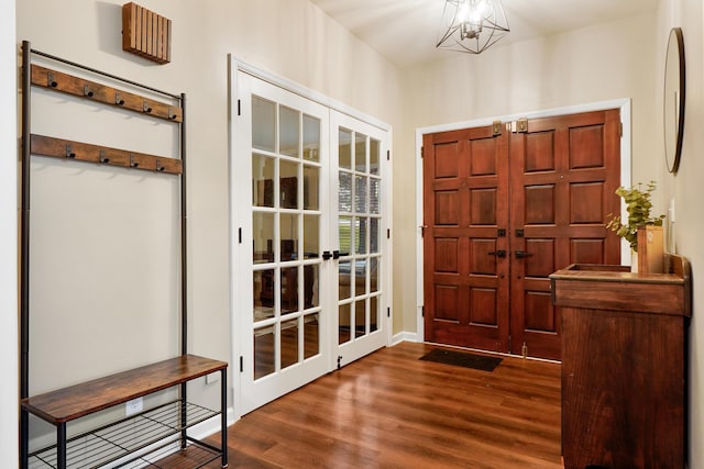 entrance foyer featuring dark wood-style flooring, french doors, and a chandelier