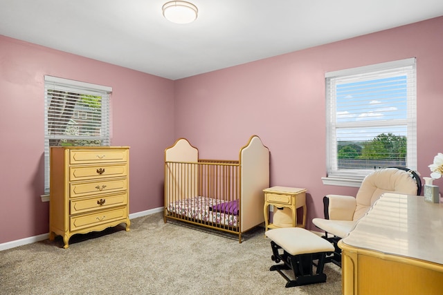 bedroom featuring light carpet, a nursery area, and baseboards