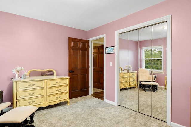 carpeted bedroom featuring baseboards and a closet