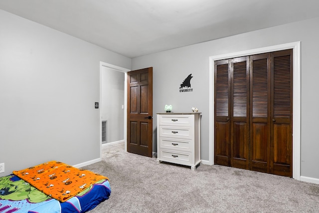 carpeted bedroom with baseboards and a closet