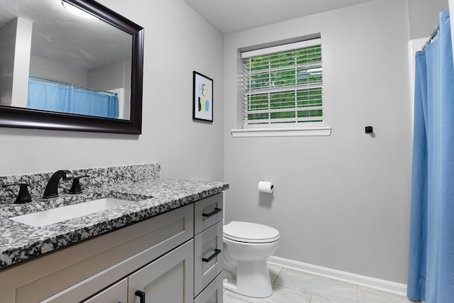 bathroom featuring toilet, baseboards, vanity, and marble finish floor