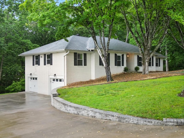 ranch-style house with concrete driveway, a front yard, brick siding, and a garage