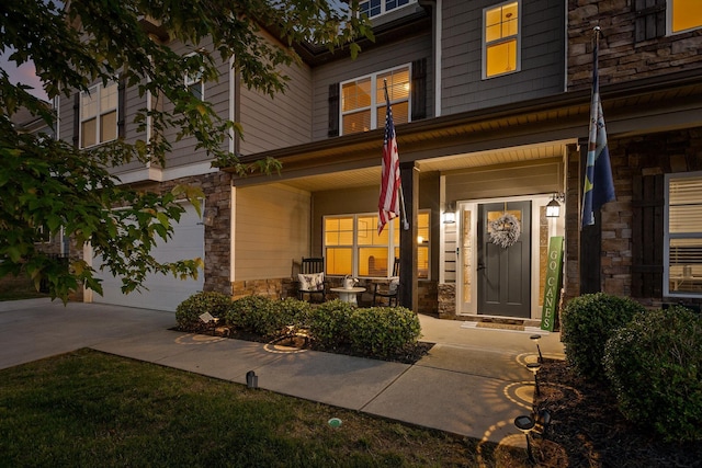 9726 Haven Port Ln, Ooltewah, TN 37363 - entrance to property featuring a porch, a garage, stone siding, and driveway