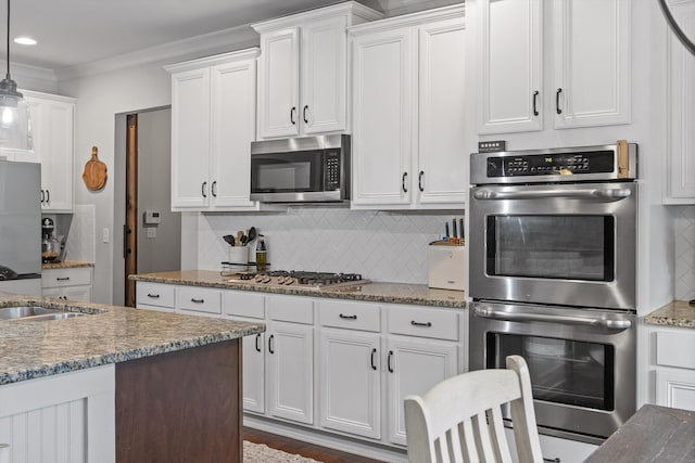 9726 Haven Port Ln, Ooltewah, TN 37363 - kitchen featuring appliances with stainless steel finishes, decorative backsplash, white cabinets, pendant lighting, and ornamental molding