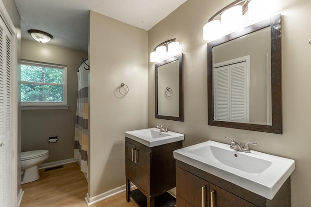 full bathroom featuring visible vents, a sink, wood finished floors, and toilet
