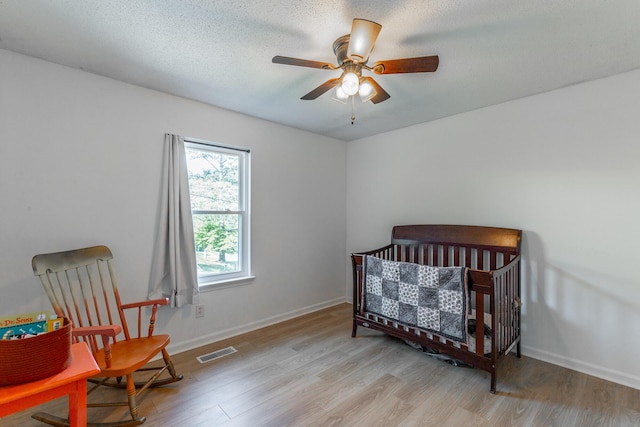 bedroom featuring visible vents, light wood-style flooring, and baseboards