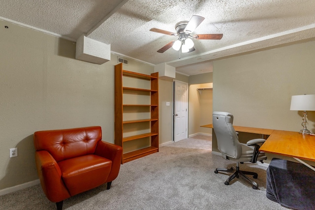carpeted home office featuring baseboards, a ceiling fan, a textured ceiling, and visible vents