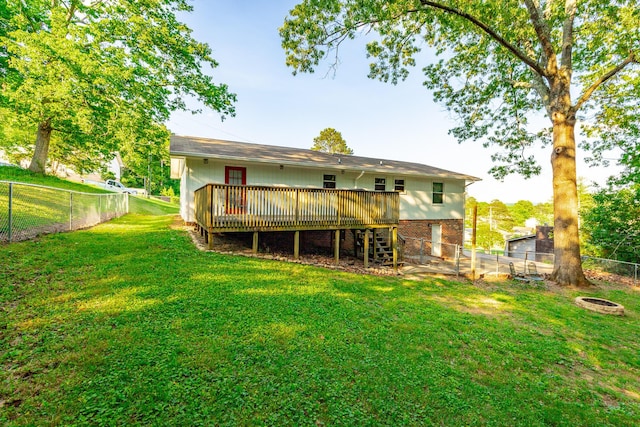 rear view of property featuring a yard, a deck, stairs, and a fenced backyard