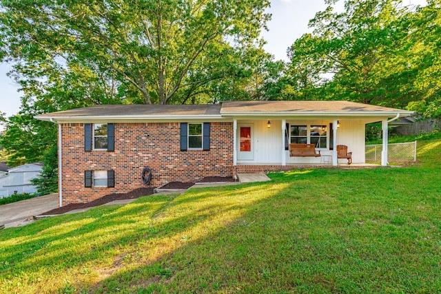 single story home featuring brick siding, fence, covered porch, and a front yard
