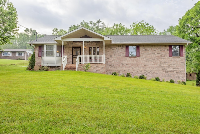 ranch-style home featuring brick siding, covered porch, and a front yard