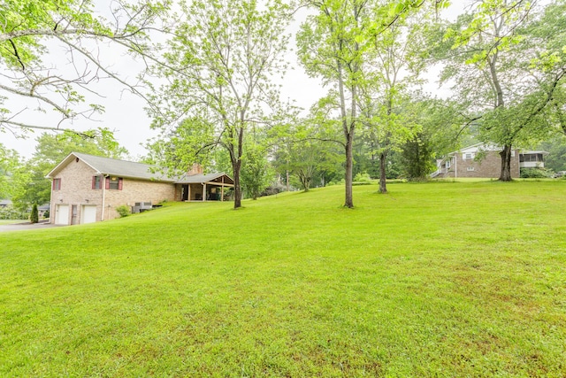 view of yard featuring an attached garage and driveway