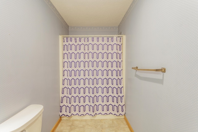 bathroom with crown molding, curtained shower, toilet, and a textured ceiling