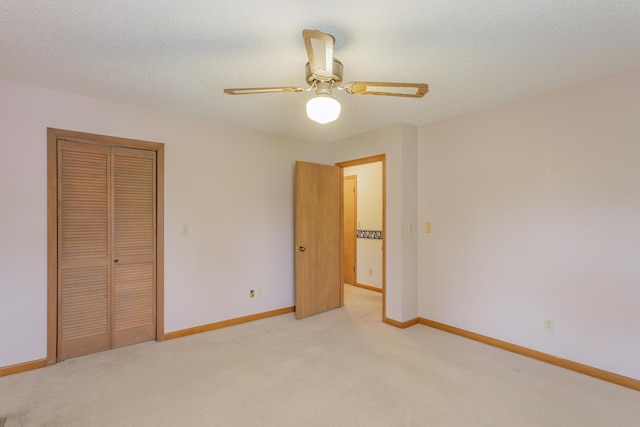 unfurnished bedroom with baseboards, a ceiling fan, a closet, and light carpet