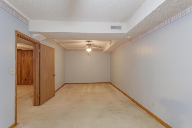 empty room with baseboards, light carpet, a ceiling fan, and visible vents