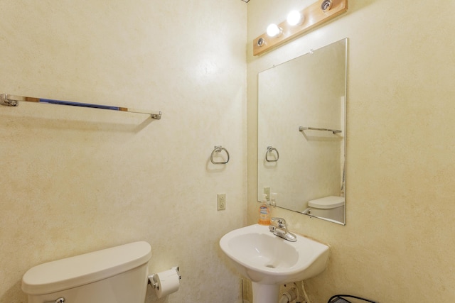 half bath featuring toilet and a sink