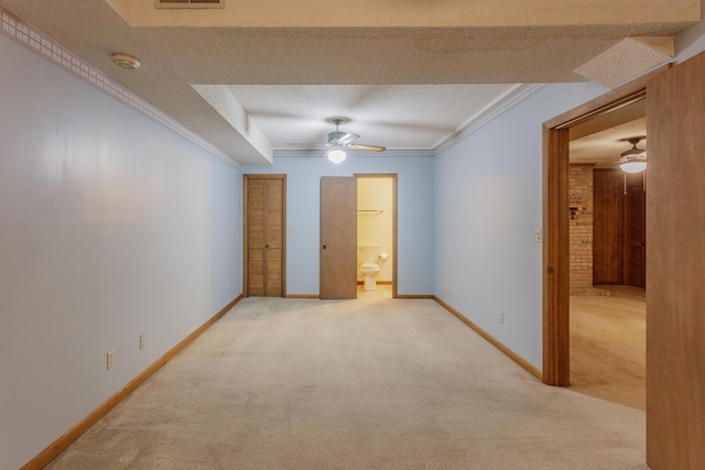 spare room featuring crown molding, a ceiling fan, and carpet