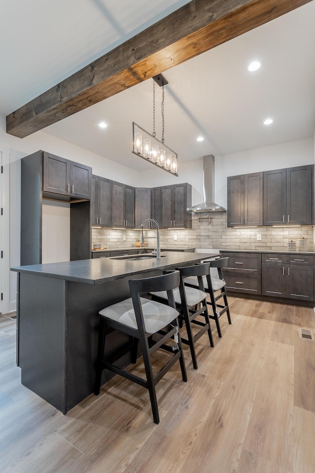 2111 Ivy St, Chattanooga, TN 37404 - kitchen with decorative backsplash, wall chimney exhaust hood, beam ceiling, and a kitchen bar