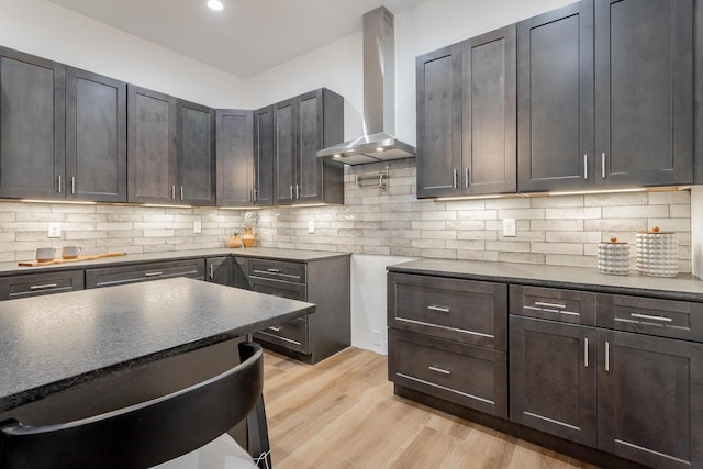 2111 Ivy St, Chattanooga, TN 37404 - kitchen featuring dark countertops, light wood-style floors, wall chimney exhaust hood, recessed lighting, and backsplash