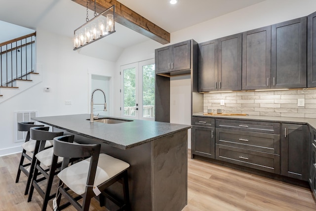 2111 Ivy St, Chattanooga, TN 37404 - kitchen featuring dark countertops, a sink, vaulted ceiling with beams, tasteful backsplash, and visible vents