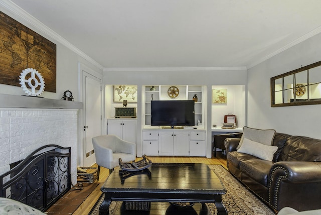 living area with a brick fireplace, crown molding, and light wood finished floors