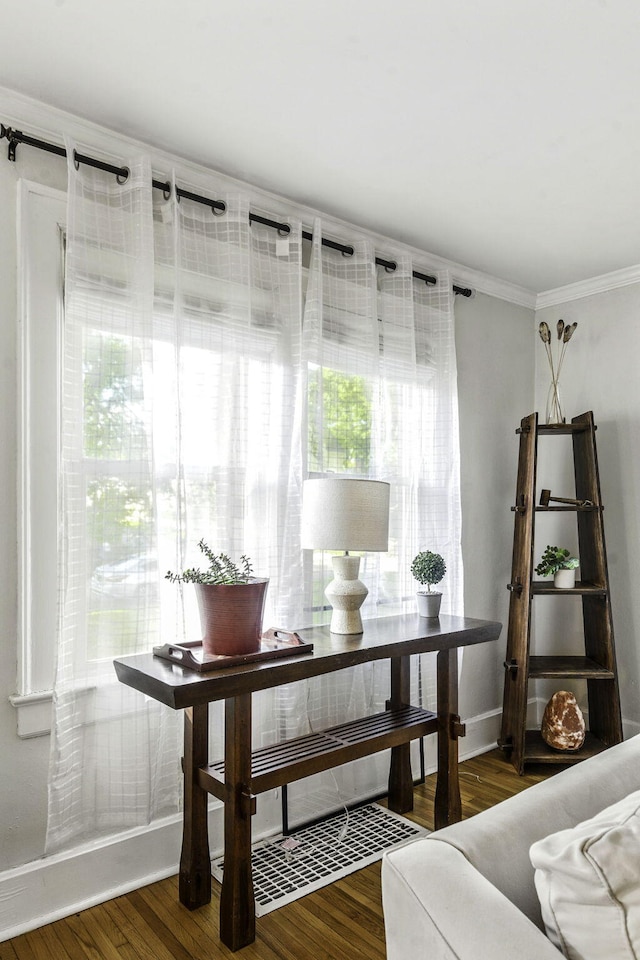 sitting room featuring baseboards, ornamental molding, and wood finished floors