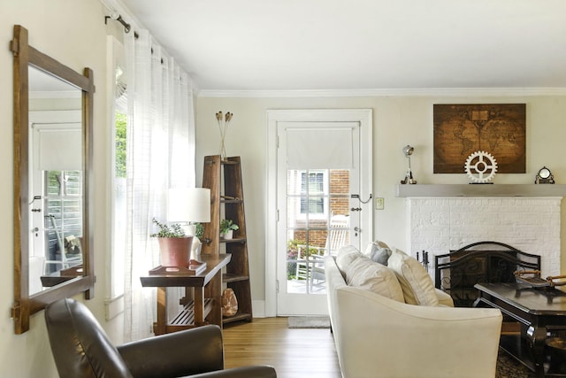 interior space featuring crown molding, a brick fireplace, plenty of natural light, and wood finished floors