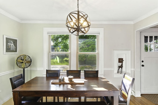 dining room with an inviting chandelier, crown molding, and wood finished floors