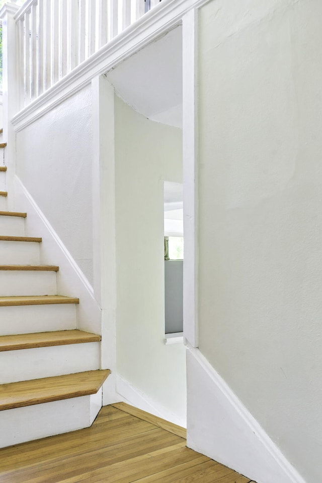 stairway with baseboards and wood finished floors