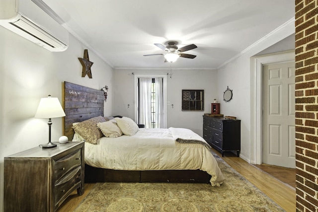 bedroom with ceiling fan, ornamental molding, wood finished floors, and a wall mounted air conditioner