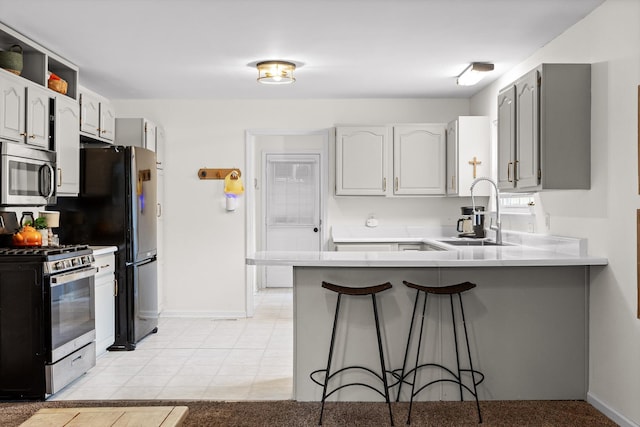 7403 Flagstone Dr, Ooltewah, TN 37363 - kitchen with appliances with stainless steel finishes, a sink, a peninsula, baseboards, and a kitchen bar