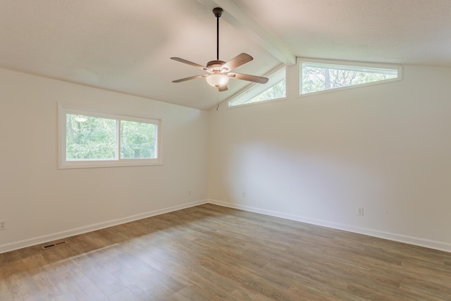 unfurnished room featuring a ceiling fan, visible vents, wood finished floors, baseboards, and vaulted ceiling with beams