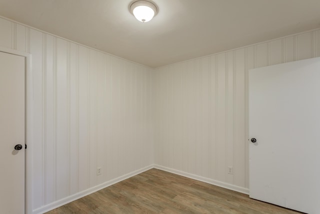 empty room with baseboards and wood finished floors