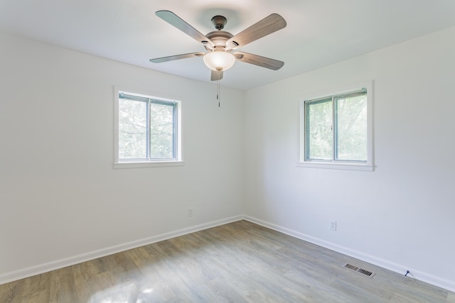 spare room featuring baseboards, plenty of natural light, and visible vents