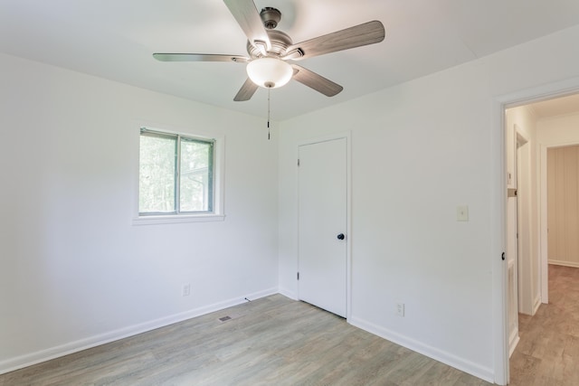unfurnished bedroom featuring baseboards, ceiling fan, a closet, and light wood finished floors